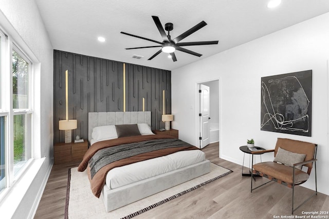 bedroom featuring hardwood / wood-style flooring, ceiling fan, a textured ceiling, and connected bathroom