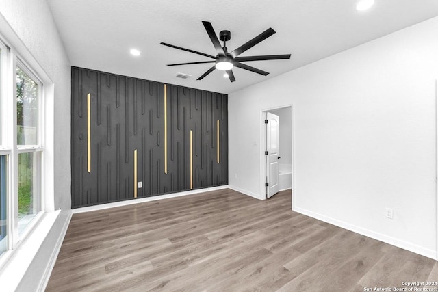 empty room with wood-type flooring, a textured ceiling, and ceiling fan