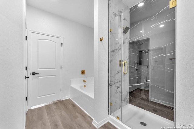 bathroom with wood-type flooring and independent shower and bath