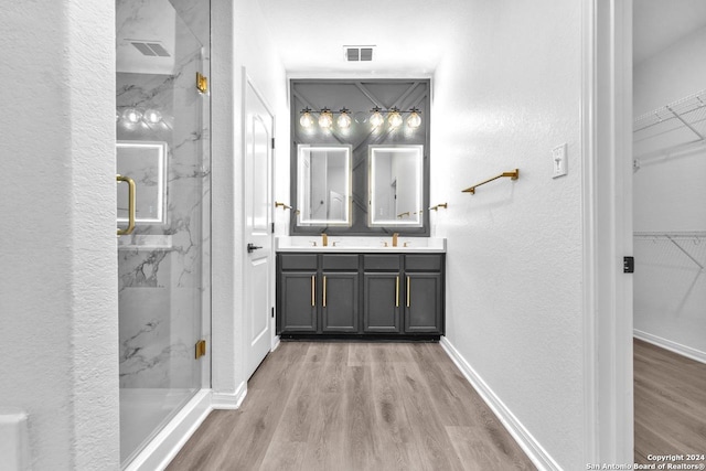 bathroom featuring vanity, wood-type flooring, and a shower with door