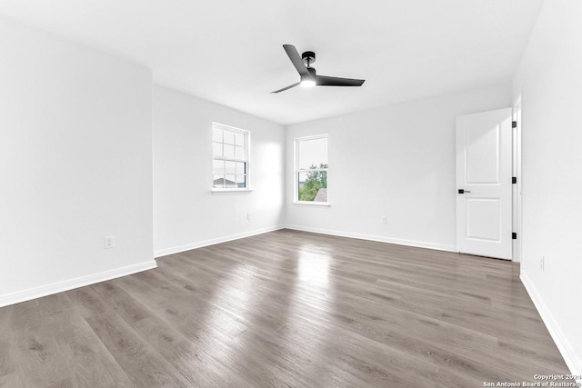 unfurnished room with dark hardwood / wood-style floors and ceiling fan