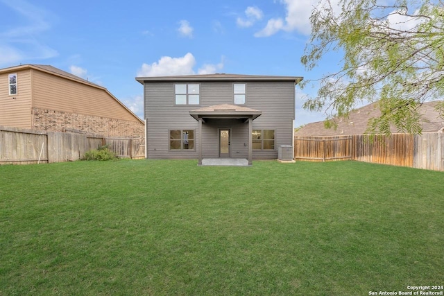 back of house featuring central air condition unit and a yard