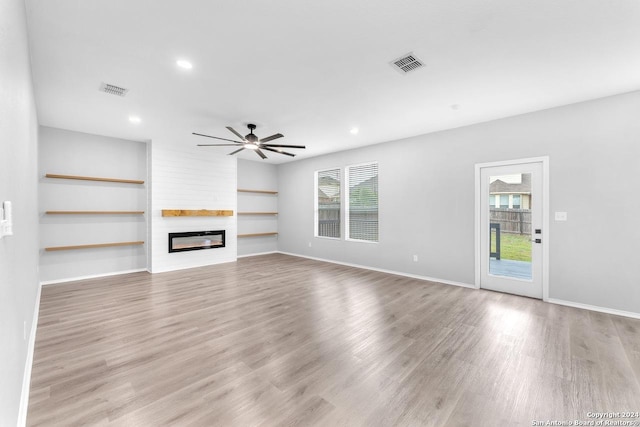 unfurnished living room with a fireplace, light hardwood / wood-style flooring, and plenty of natural light