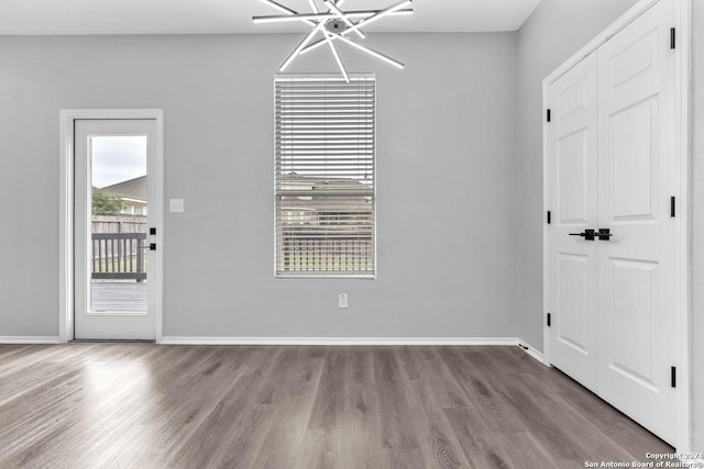 unfurnished dining area featuring hardwood / wood-style floors and a notable chandelier