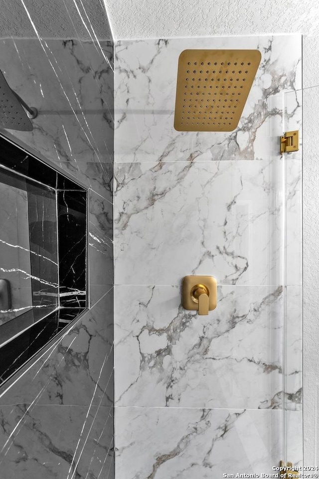 interior details with a tile shower