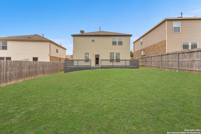 rear view of house with a yard and a wooden deck