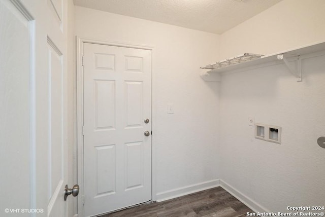 clothes washing area with electric dryer hookup, hookup for a washing machine, dark hardwood / wood-style flooring, and a textured ceiling