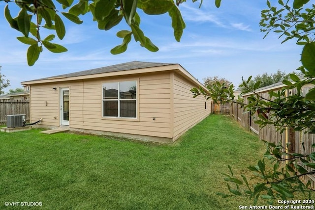 back of house with a lawn and cooling unit