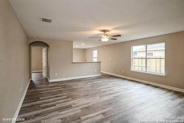 spare room with dark hardwood / wood-style floors, ceiling fan, and a textured ceiling