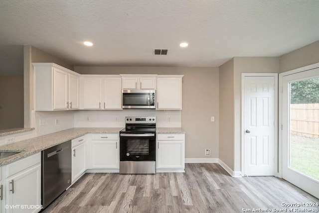 kitchen featuring a healthy amount of sunlight, white cabinetry, and stainless steel appliances