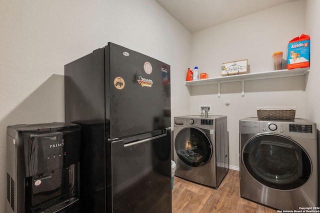 clothes washing area with washer and clothes dryer and hardwood / wood-style floors