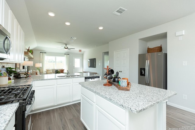 kitchen featuring sink, a kitchen island, appliances with stainless steel finishes, and white cabinets