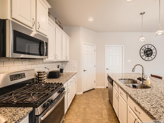 kitchen with sink, decorative light fixtures, light stone counters, white cabinetry, and stainless steel appliances