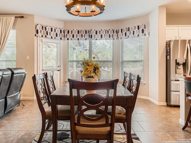 tiled dining space featuring a notable chandelier