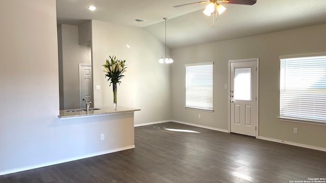 interior space with dark hardwood / wood-style floors, sink, lofted ceiling, and ceiling fan with notable chandelier