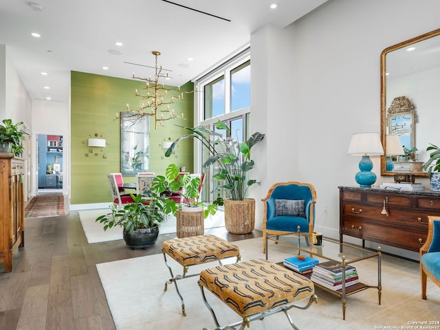 sitting room with hardwood / wood-style flooring and an inviting chandelier