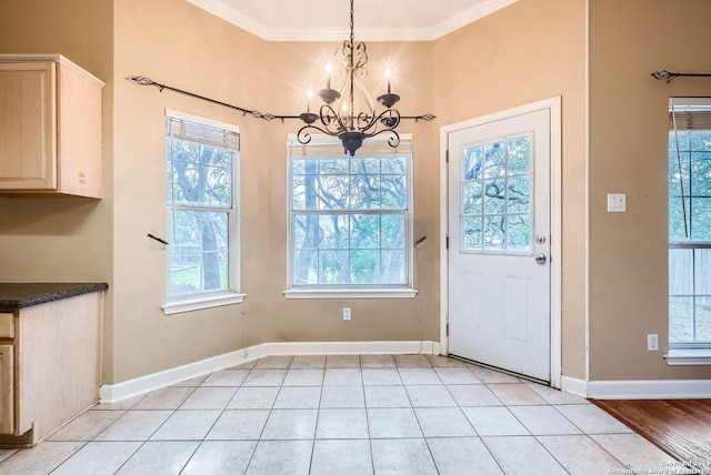 unfurnished dining area with a notable chandelier, light hardwood / wood-style floors, ornamental molding, and a wealth of natural light