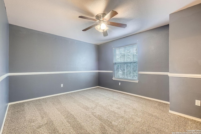 empty room featuring ceiling fan, carpet floors, and a textured ceiling