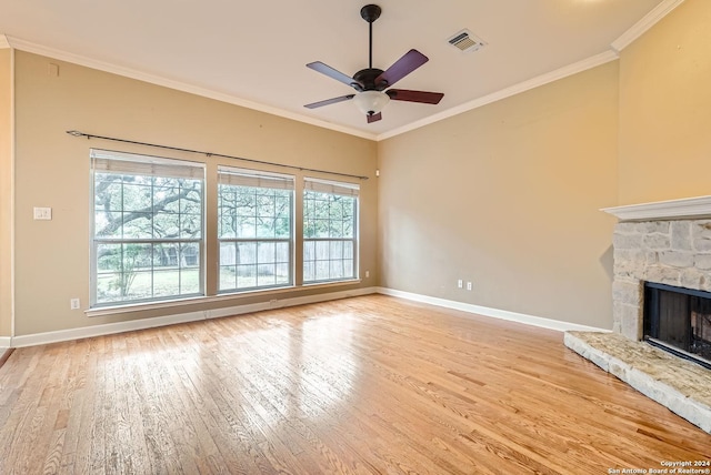 unfurnished living room featuring a healthy amount of sunlight, ornamental molding, and light hardwood / wood-style flooring