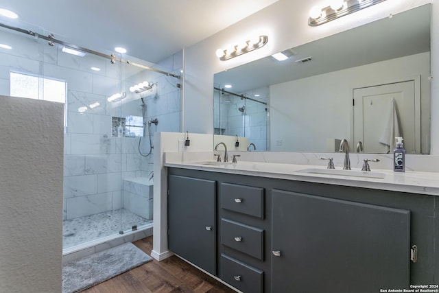 bathroom featuring vanity, hardwood / wood-style flooring, and a shower with shower door