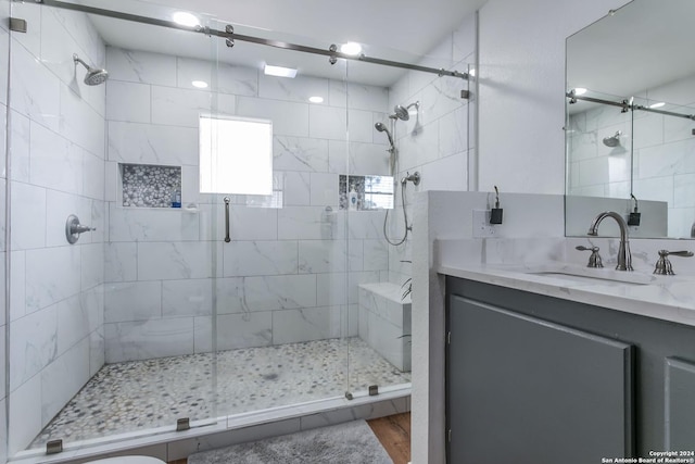 bathroom with vanity, hardwood / wood-style flooring, and a shower with shower door