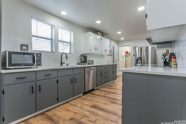 kitchen featuring stainless steel appliances, gray cabinets, light hardwood / wood-style floors, and sink