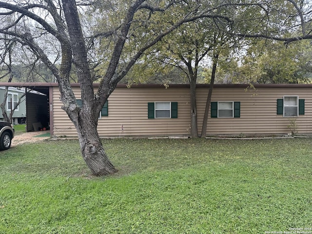 view of property exterior with a carport and a lawn