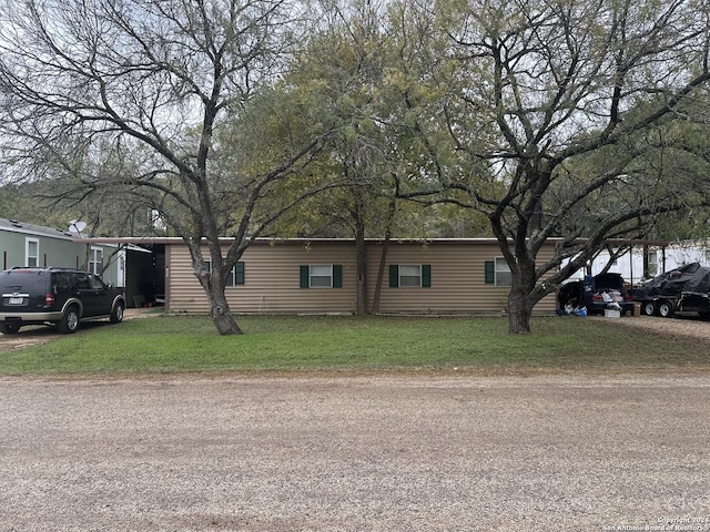 manufactured / mobile home with a front yard and a carport