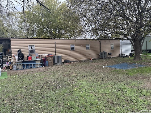 back of property featuring a yard and central AC unit