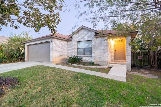 ranch-style house featuring a garage and a front lawn