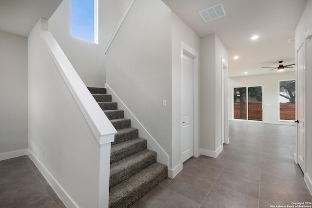 staircase with tile patterned flooring and ceiling fan