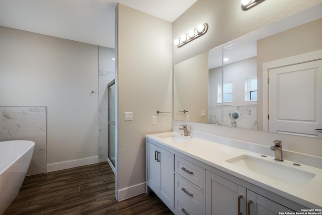 bathroom with hardwood / wood-style floors, vanity, and shower with separate bathtub