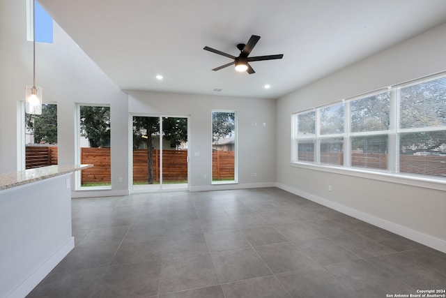 tiled spare room with ceiling fan