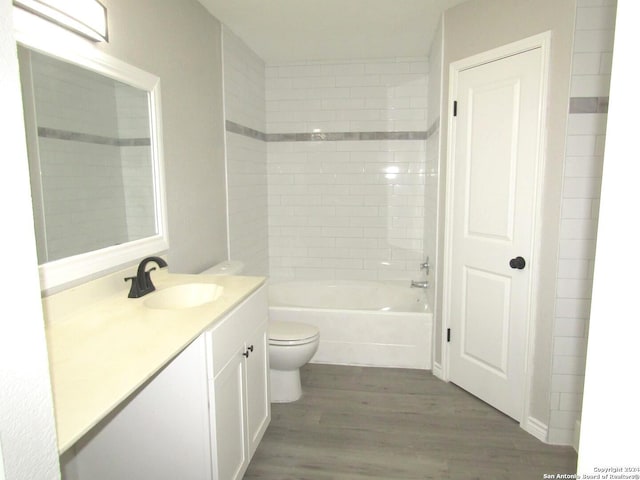 full bathroom with vanity, hardwood / wood-style flooring, toilet, and tiled shower / bath