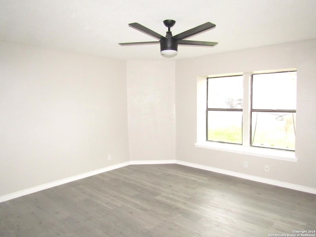 spare room with dark hardwood / wood-style flooring and ceiling fan