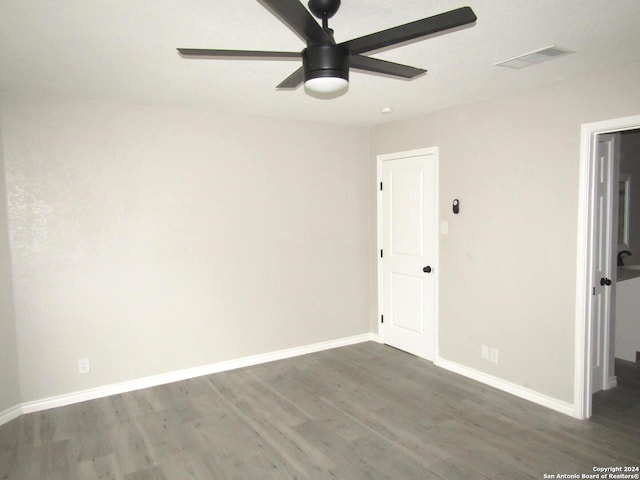 empty room with ceiling fan and dark wood-type flooring