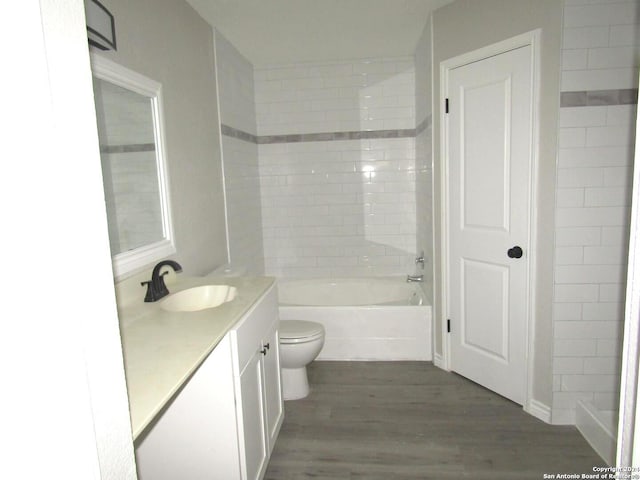 full bathroom featuring toilet, vanity, tiled shower / bath combo, and hardwood / wood-style flooring