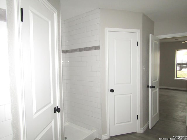 bathroom featuring hardwood / wood-style floors and a tile shower