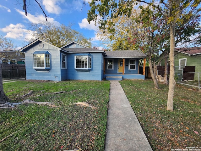 single story home featuring a porch and a front yard