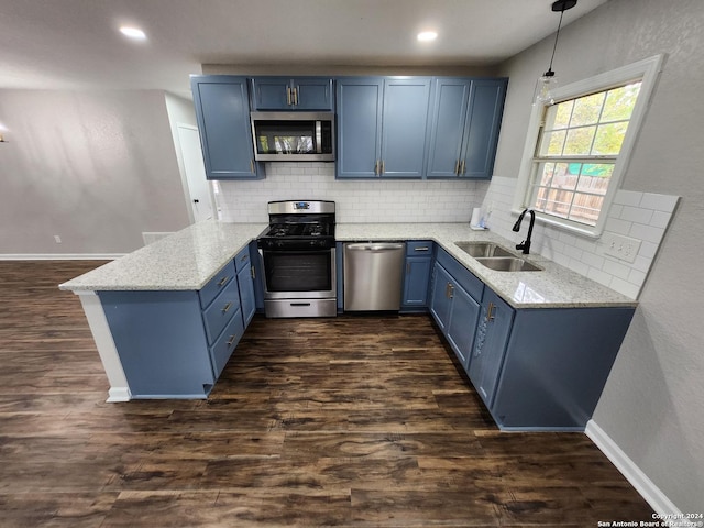 kitchen featuring kitchen peninsula, decorative light fixtures, stainless steel appliances, tasteful backsplash, and sink