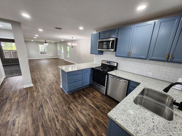 kitchen with stainless steel appliances, kitchen peninsula, ceiling fan, sink, and blue cabinets