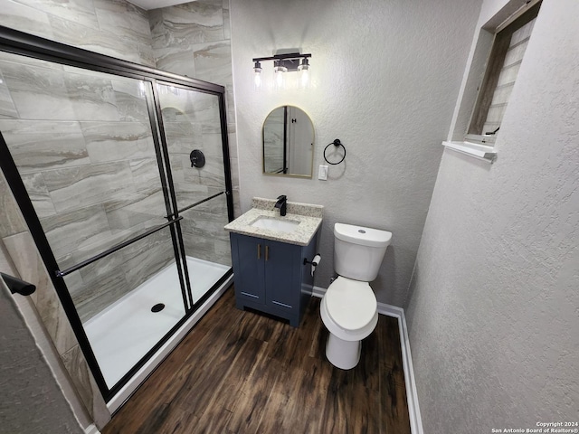 bathroom with a shower with door, toilet, vanity, and hardwood / wood-style flooring