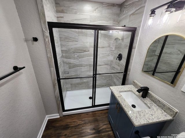 bathroom featuring an enclosed shower, vanity, and hardwood / wood-style flooring