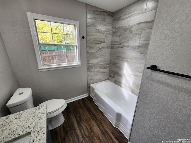 full bathroom with tiled shower / bath, toilet, vanity, and wood-type flooring