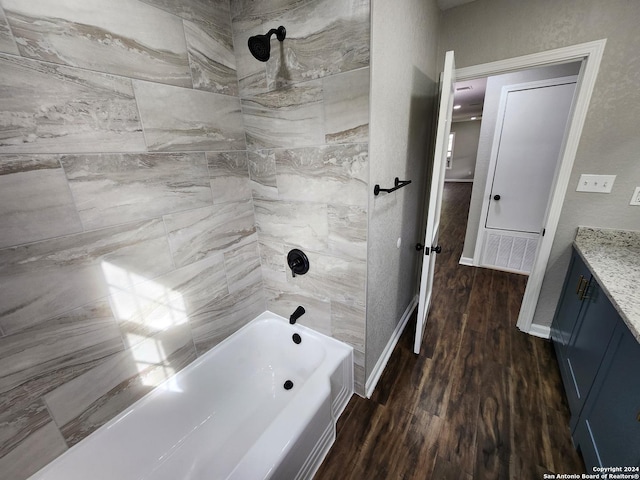 bathroom featuring tiled shower / bath combo, vanity, and hardwood / wood-style floors