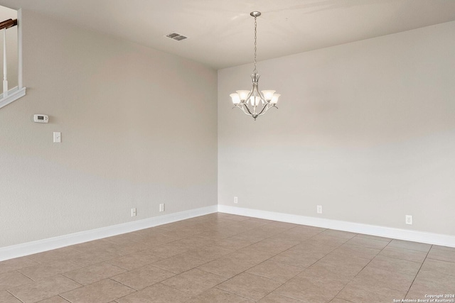 tiled empty room with a chandelier