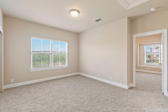 spare room with a textured ceiling and light carpet