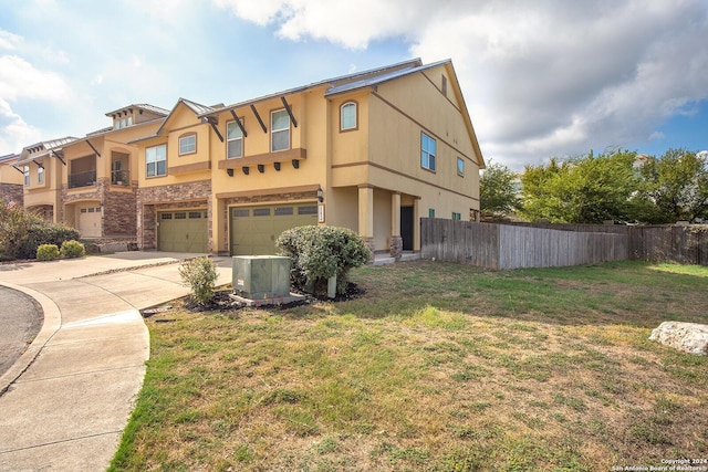 view of front of home featuring a front lawn, a garage, and central AC unit