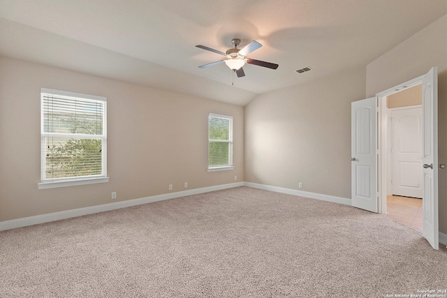 spare room with plenty of natural light, ceiling fan, light colored carpet, and lofted ceiling