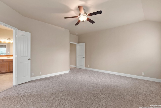 unfurnished bedroom with ensuite bathroom, vaulted ceiling, ceiling fan, and light colored carpet